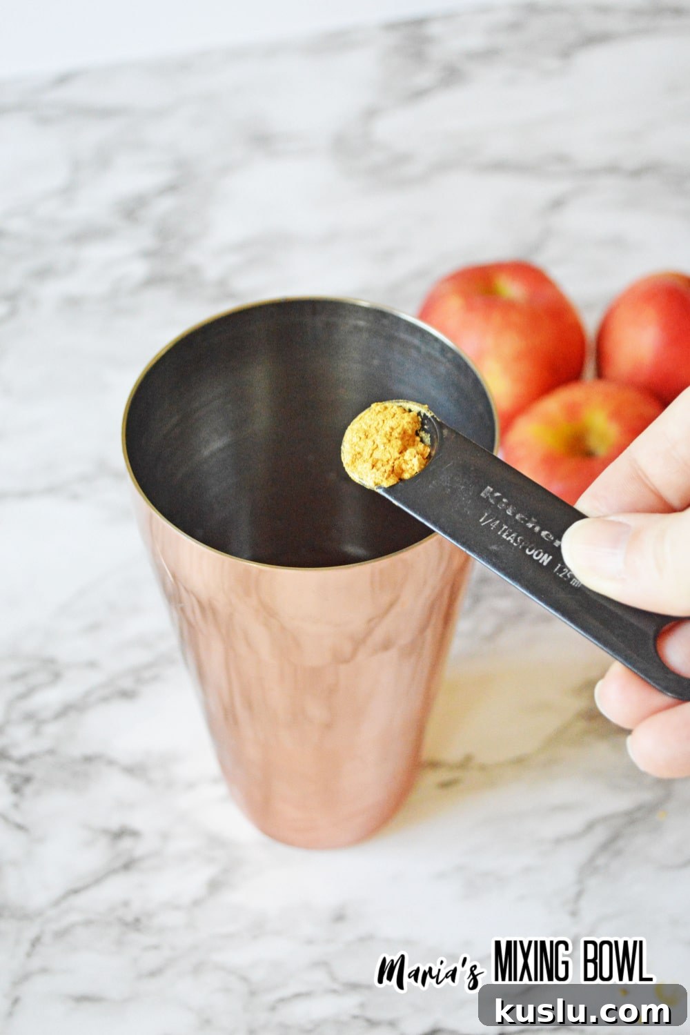 seasoning being added to a cocktail shaker