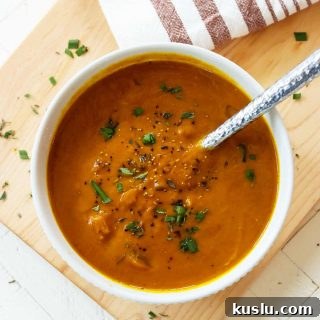 pumpkin soup in a white bowl with a spoon.