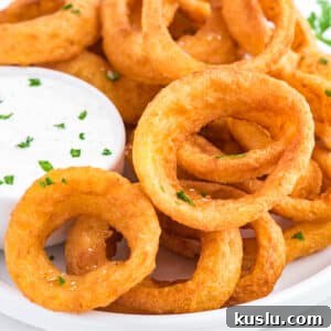 Crispy Frozen Onion Rings in the Air Fryer: Quick Recipe Guide 12 Onion rings made in the air fryer on a plate with a side of ranch dressing.