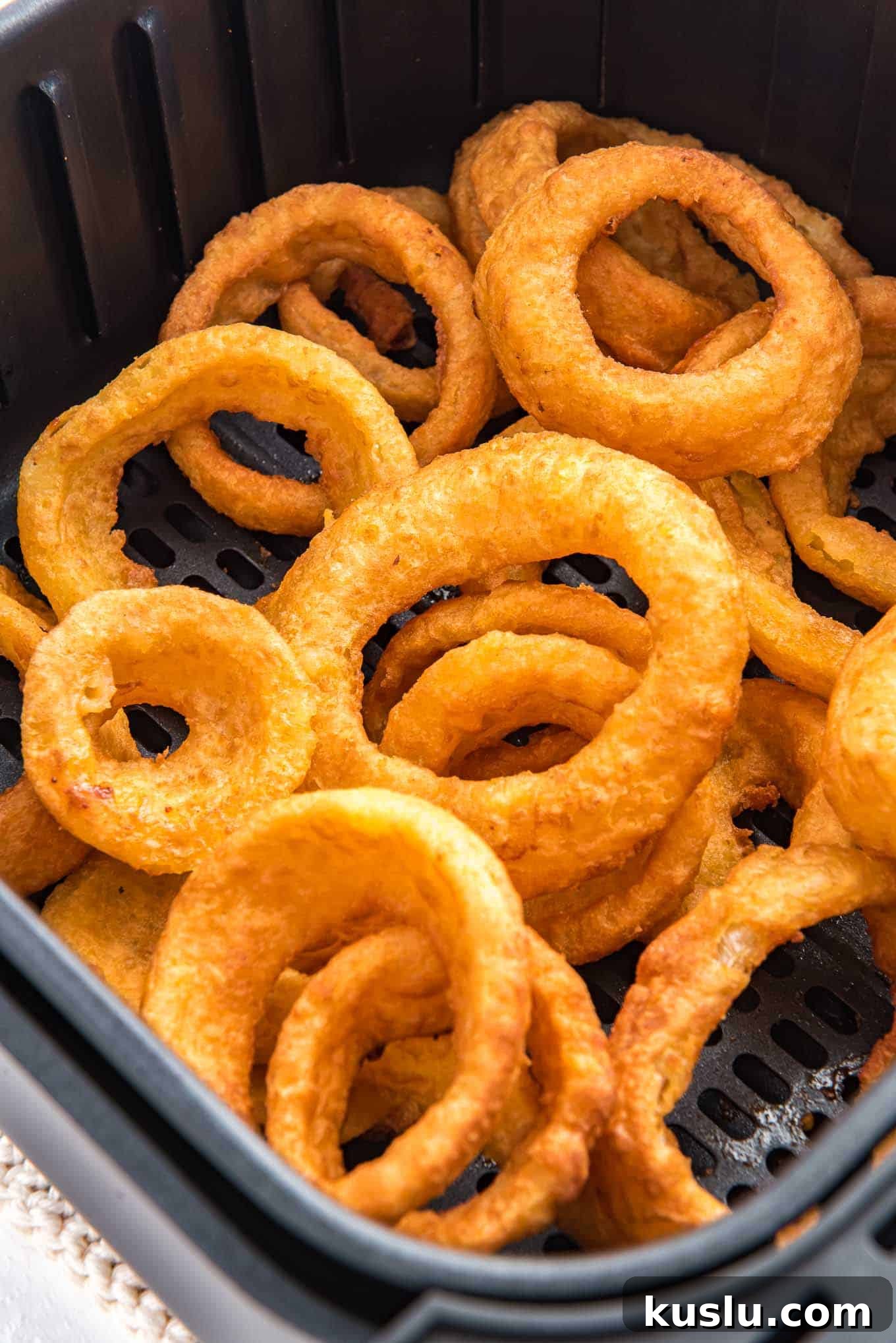 Crispy Frozen Onion Rings in the Air Fryer: Quick Recipe Guide 6 A closeup image of onion rings in an air fryer basket.