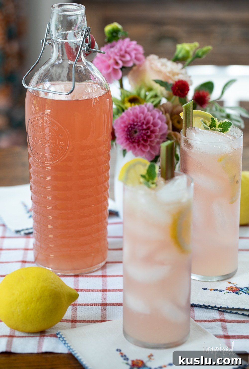 Homemade Rhubarb and Ginger Infused Vodka Recipe 12 large glass bottle filled with homemade rhubarb ginger vodka and two cocktails.