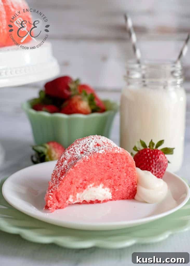 Slice of Strawberry Bundt Cake with Marshmallow Cream Filling on plate with glass of milk and bowl of strawberries in the background