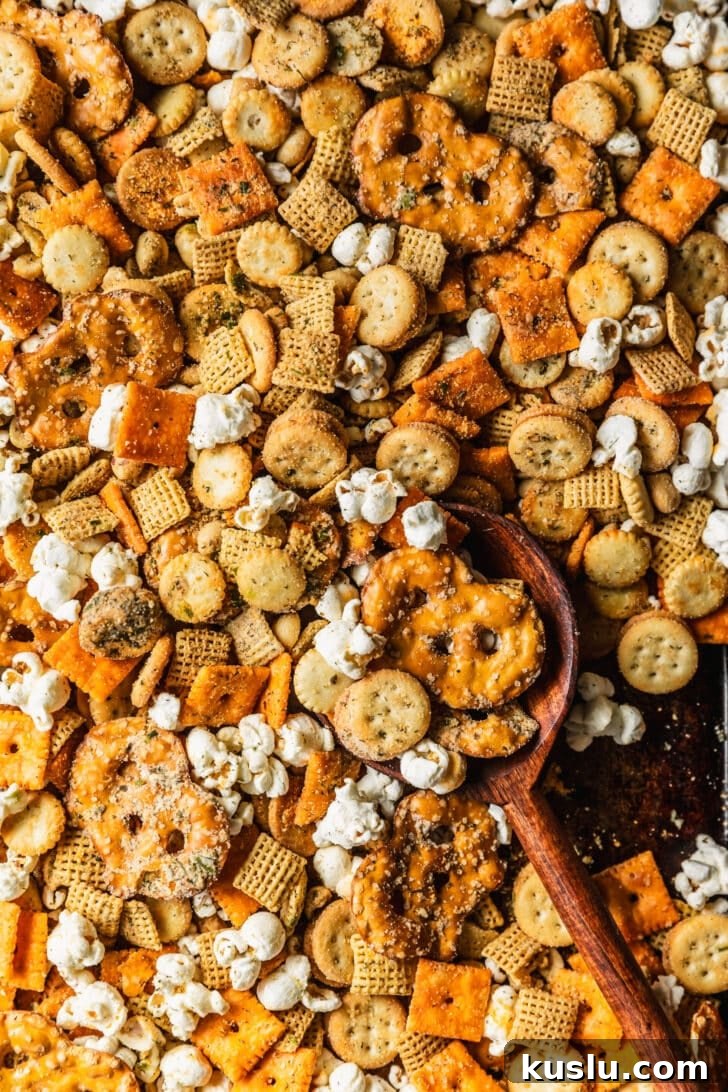 Spicy Ranch Snack Mix Recipe: Zesty Party Mix Everyone Loves 10 A wood spoon scooping spicy ranch Chex mix.