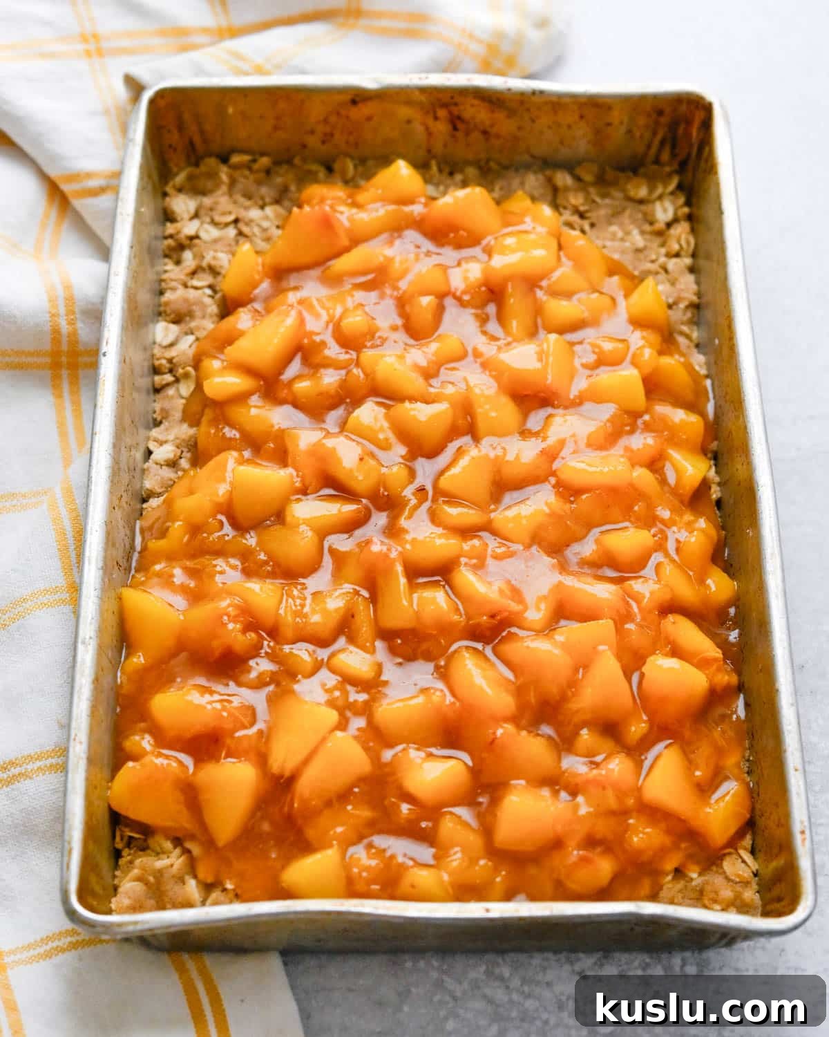 Topping the cookie base with fresh peach filling.