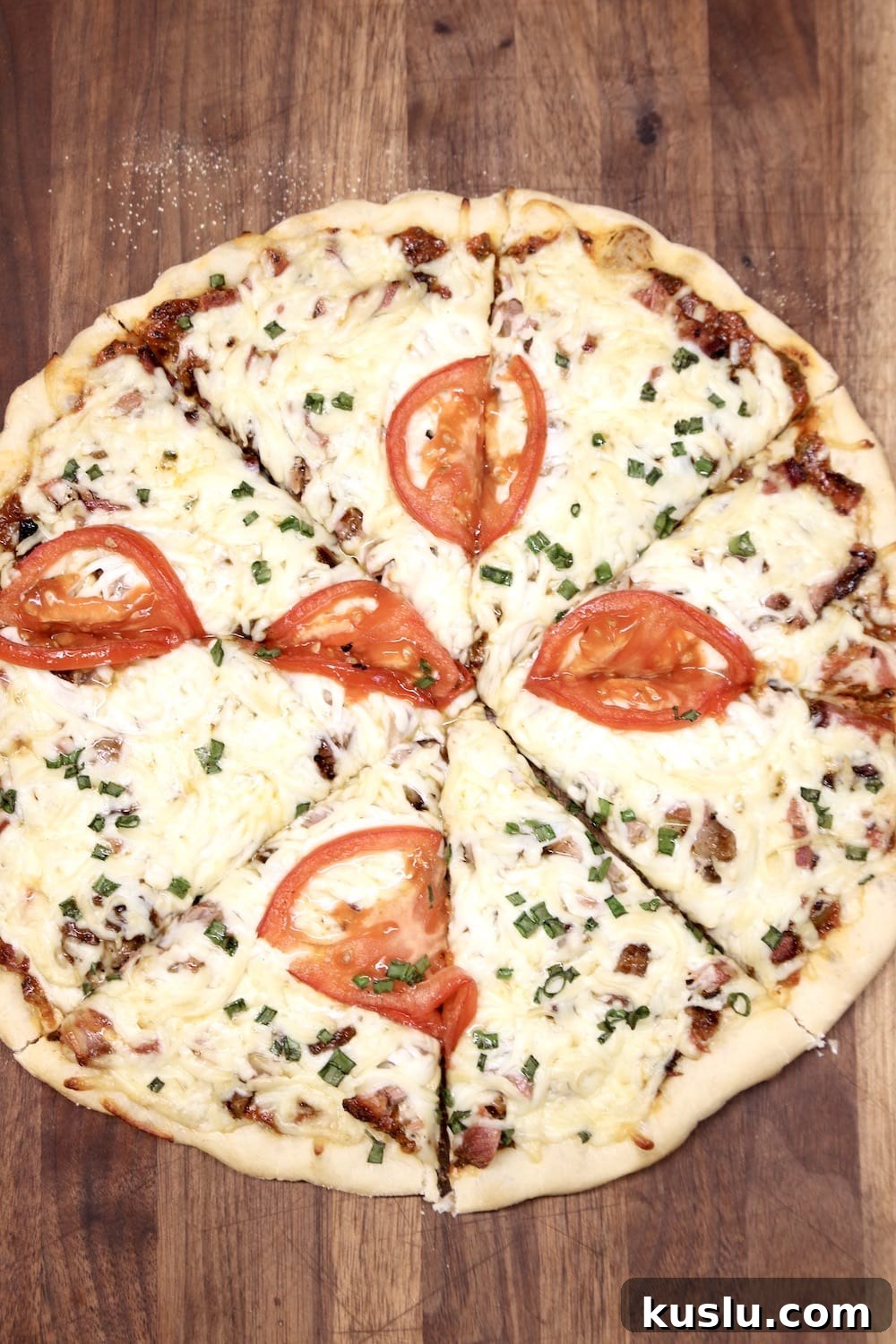 Grilled pizza made with leftover brisket sliced pizza on a cutting board