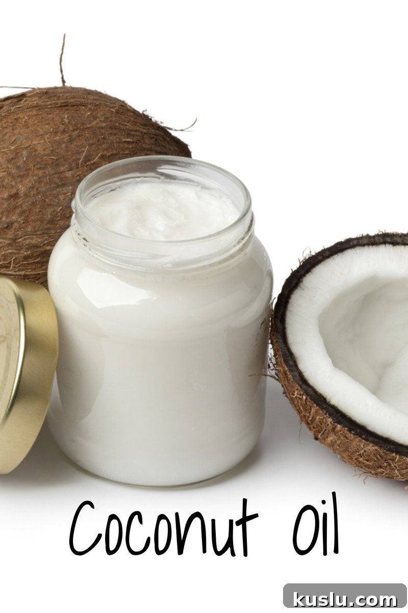 jar of coconut oil with two coconuts next to it