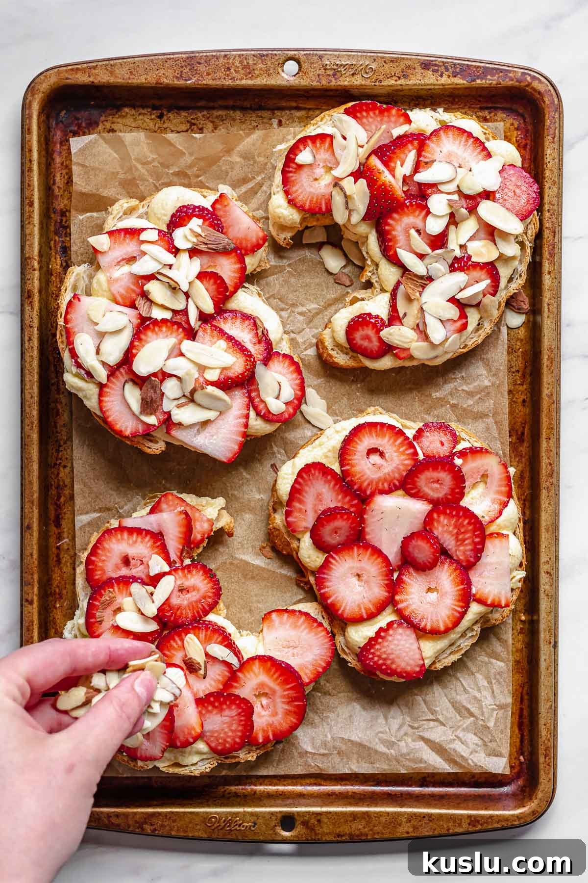 Strawberry Almond Bostock Made from Croissant Pastry 8 Slivered almonds getting sprinkled on the strawberries.