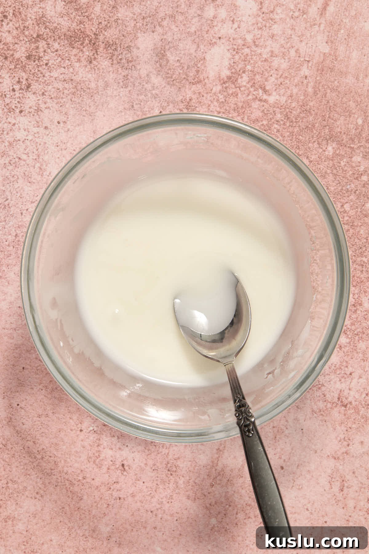 Powdered sugar glaze mixed together in a small bowl with a spoon.