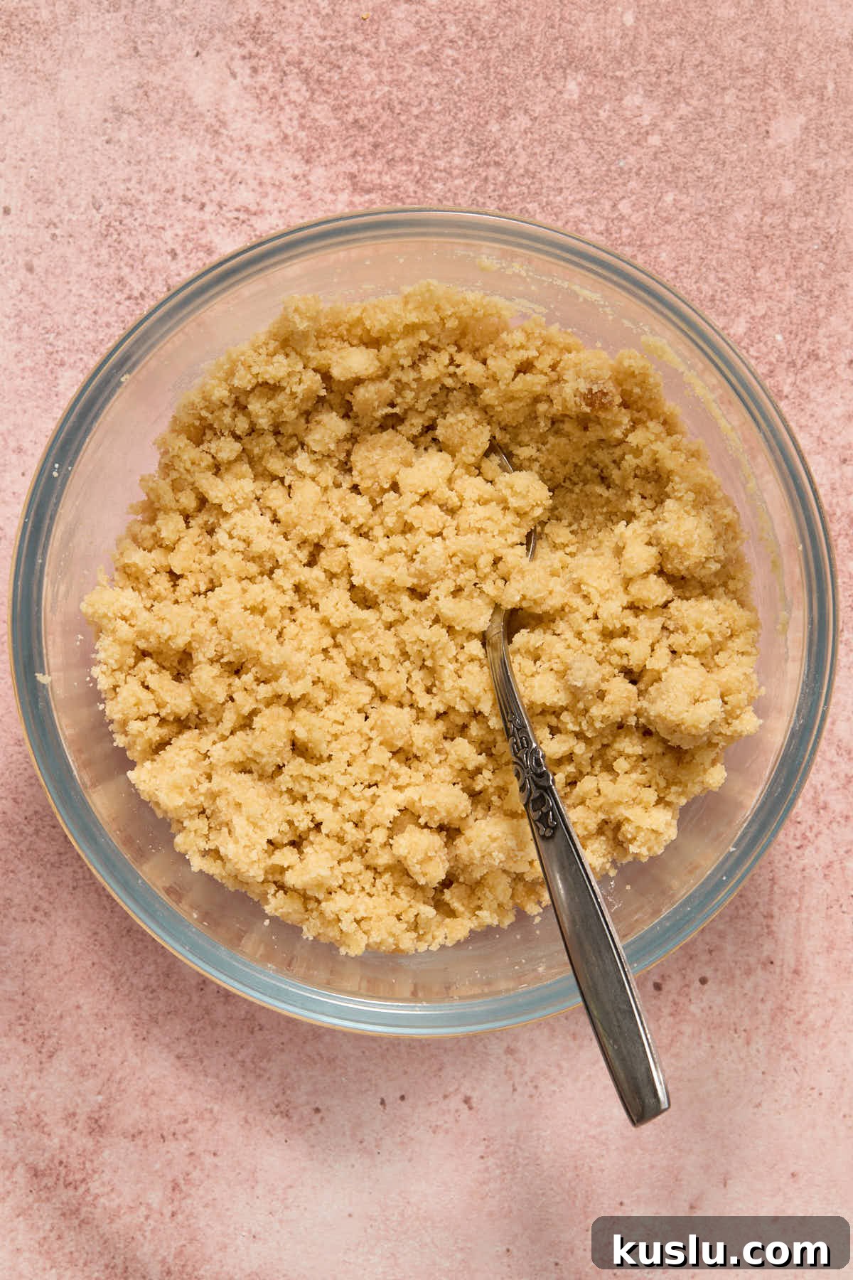 Crumb topping mixed together in a glass bowl with a fork.
