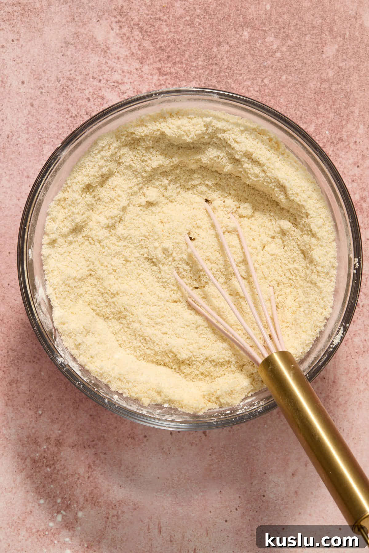 Dry ingredients for cake batter whisked together in a glass bowl.
