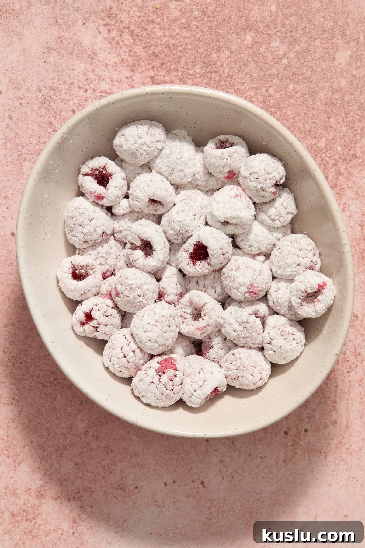 Raspberries tossed with cornstarch in a white bowl.