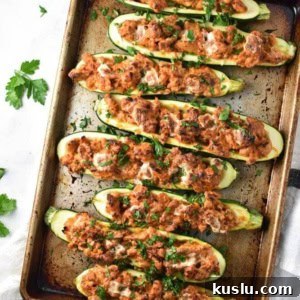Italian Chicken Zucchini Boats Recipe — Savory Stuffed Zucchini 5 A row of zucchini boats neatly stacked on a baking sheet