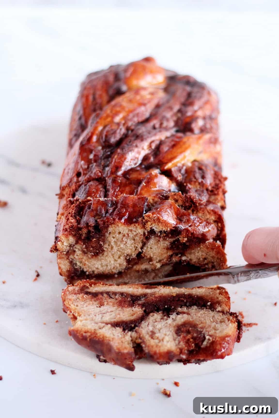 chocolate babka with almond filling first slice cutting on white table