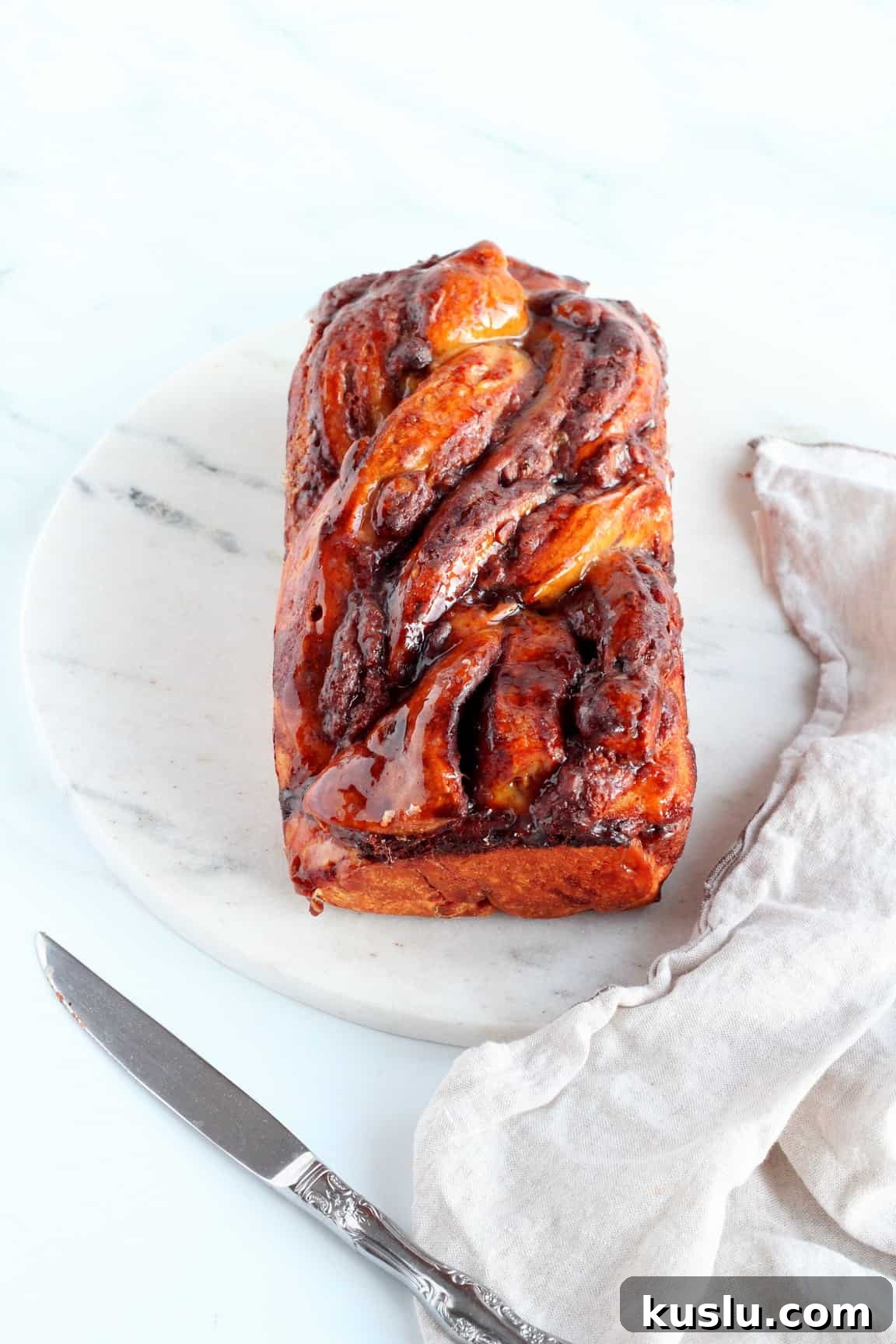 loaf of chocolate babka with almond filling on marble tray
