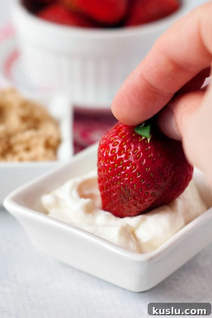Strawberry being dipped in sour cream