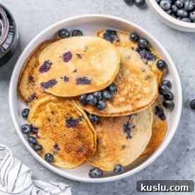 Lemon Blueberry Ricotta Pancakes Recipe for Fluffy, Tangy Stacks 12 top view of blueberry lemon ricotta pancakes on a round white plate