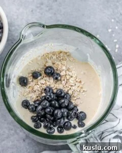 Lemon Blueberry Ricotta Pancakes Recipe for Fluffy, Tangy Stacks 14 Stirring oats and blueberries into pancake batter.