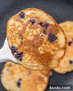 Lemon Blueberry Ricotta Pancakes Recipe for Fluffy, Tangy Stacks 15 Flipping a lemon blueberry pancake.