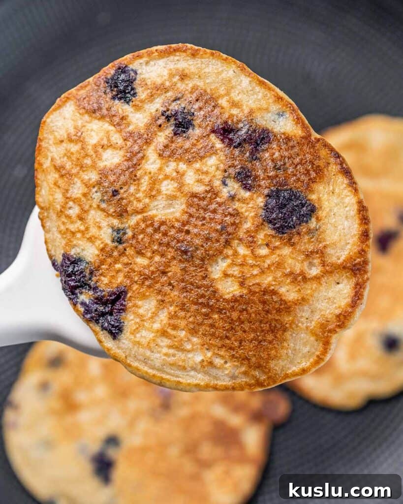 Lemon Blueberry Ricotta Pancakes Recipe for Fluffy, Tangy Stacks 6 Flipping a lemon blueberry pancake.
