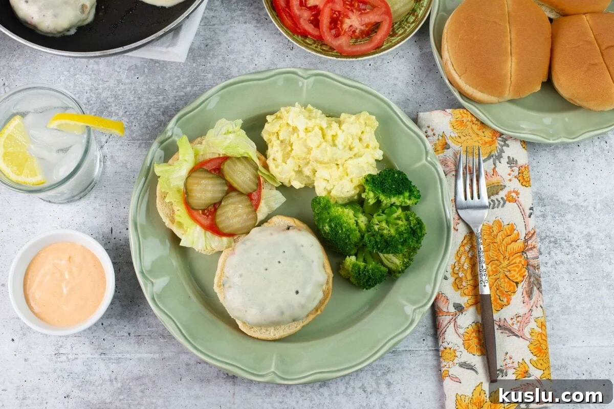 Juicy Grilled Chicken Burgers with Flavorful Toppings 6 Plated chicken burger with potato salad, broccoli, and toppings.