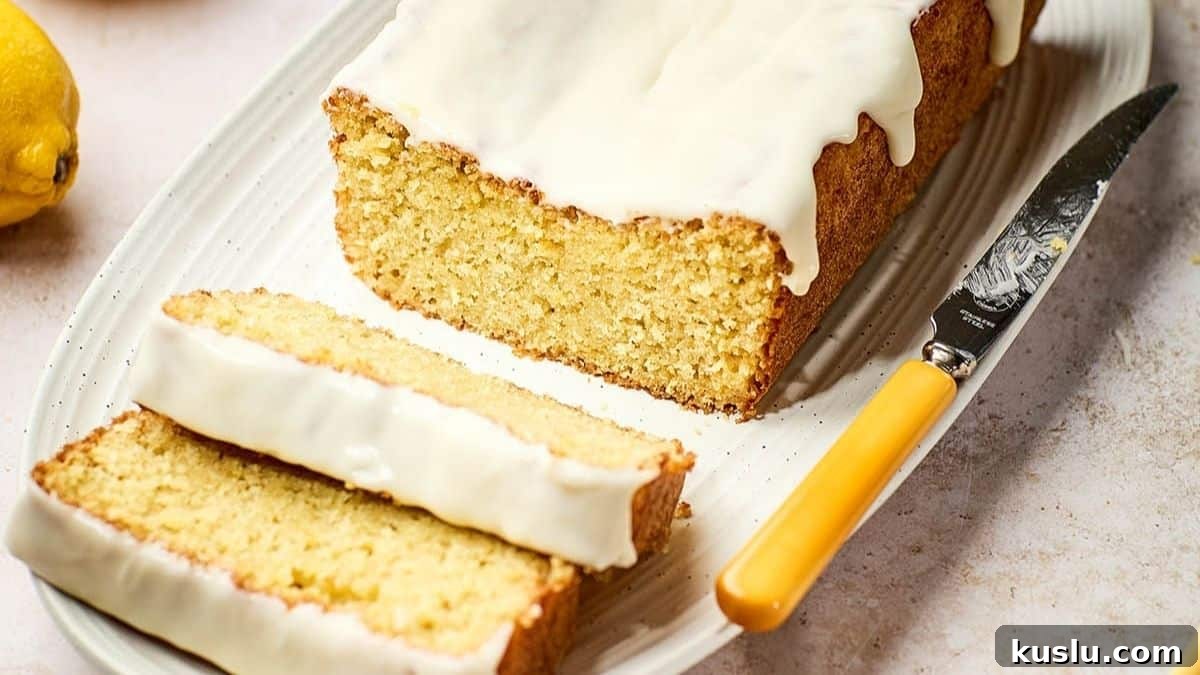 Sourdough Discard Recipes You’ll Want to Make Again and Again 11 Sourdough lemon loaf cake with glaze, sliced to show tender crumb on a serving plate.