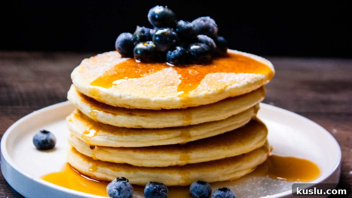 Sourdough Discard Recipes You’ll Want to Make Again and Again 5 A stack of sourdough discard pancakes drizzled with maple syrup and topped with berries.