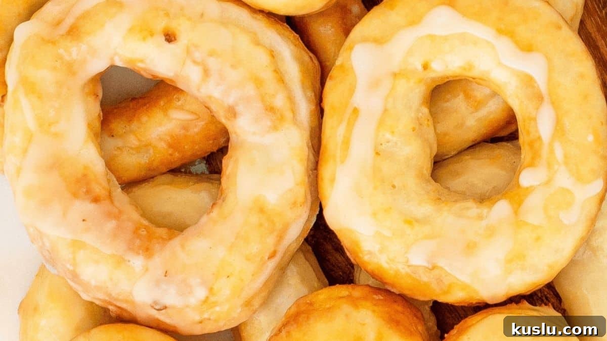 Sourdough Discard Recipes You’ll Want to Make Again and Again 9 Air fryer sourdough discard donuts glazed and stacked on a plate.
