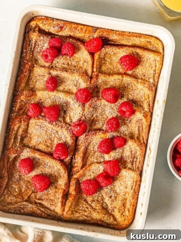 French toast bake topped with raspberries in a baking pan.