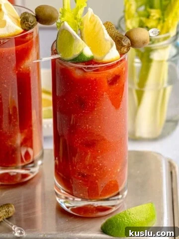 Virgin bloody marys garnished with lemon and lime wedges.