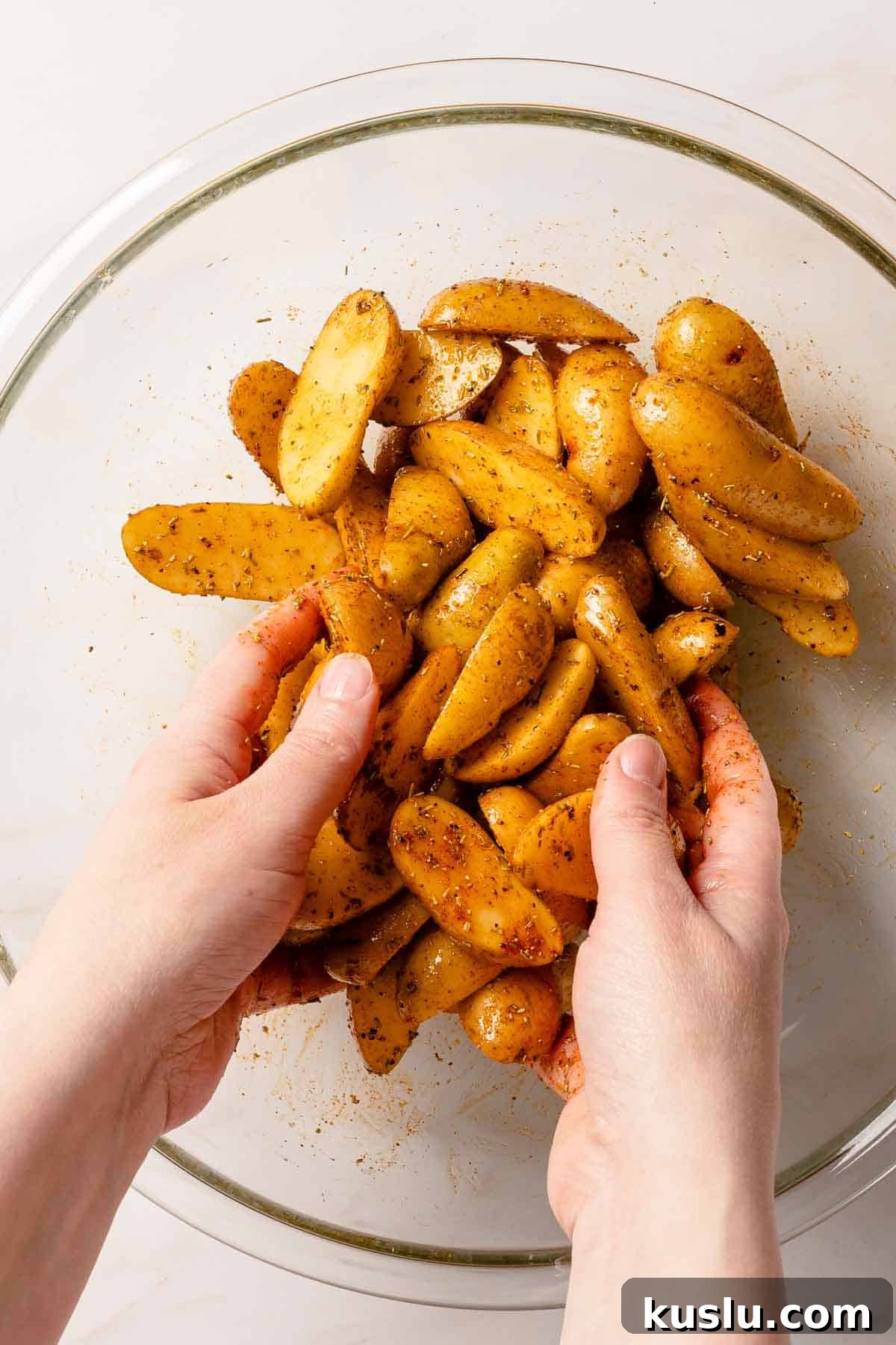 Crispy Air Fryer Fingerling Potatoes Recipe 8 hands tossing potatoes with seasonings in bowl