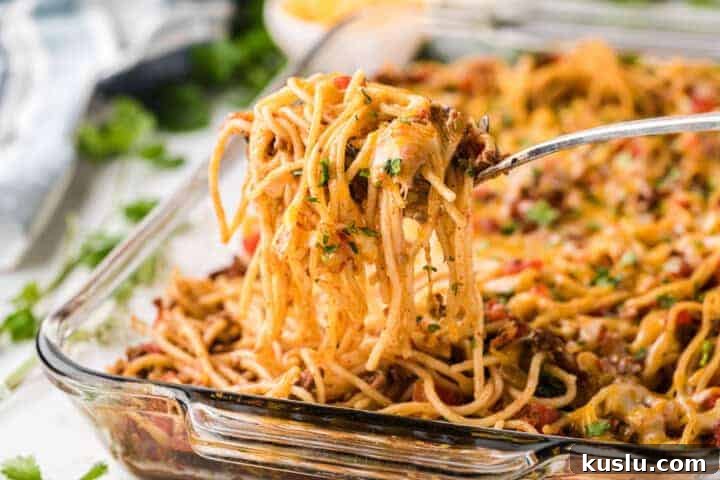 Simple Weeknight Dinner Recipes for Busy Families 12 Taco Spaghetti being served out of a glass casserole dish.