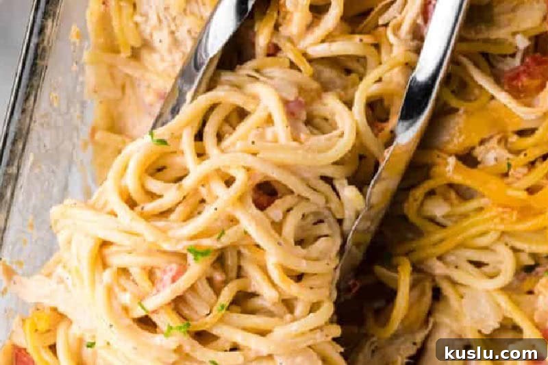 Simple Weeknight Dinner Recipes for Busy Families 7 Chicken Spaghetti Casserole being served with tongs.