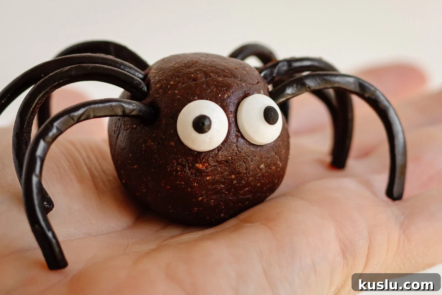 A Halloween spider energy ball sitting on the palm of a hand.