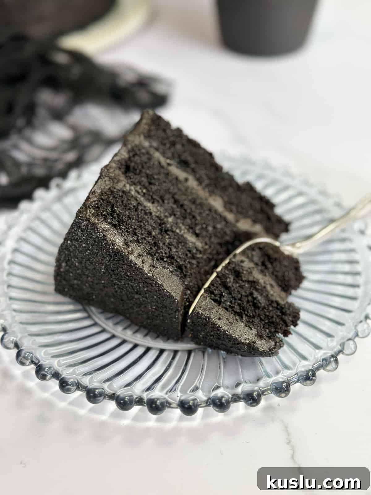 a slice of black chocolate cake on a plate.
