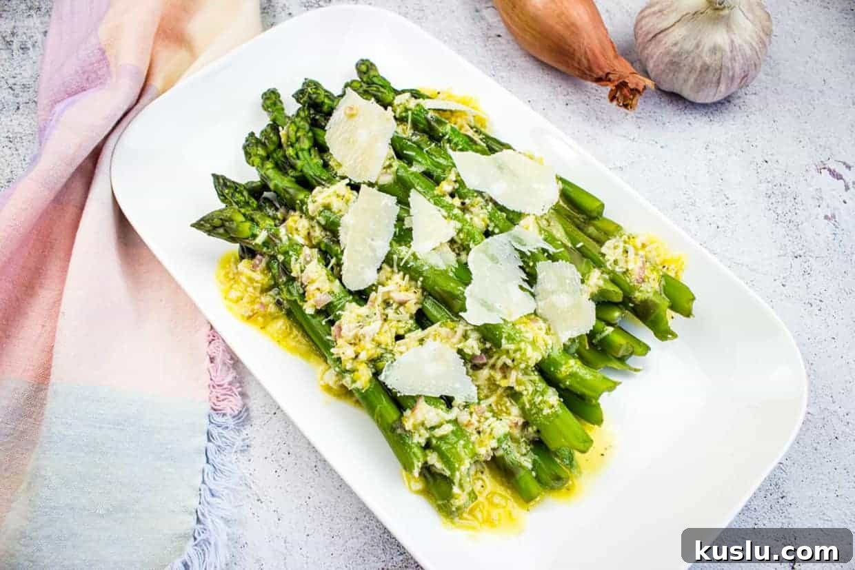 17 Tangy Lemon Recipes Made for Flavor, Not Fancy Presentation 11 Asparagus with Lemon and Parmesan on a white platter.