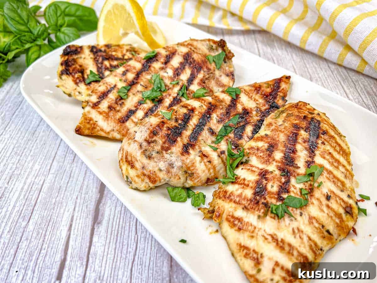 17 Tangy Lemon Recipes Made for Flavor, Not Fancy Presentation 13 Four pieces of Ninja Woodfire Grill Lemon-Herb Chicken served on a white rectangular plate.