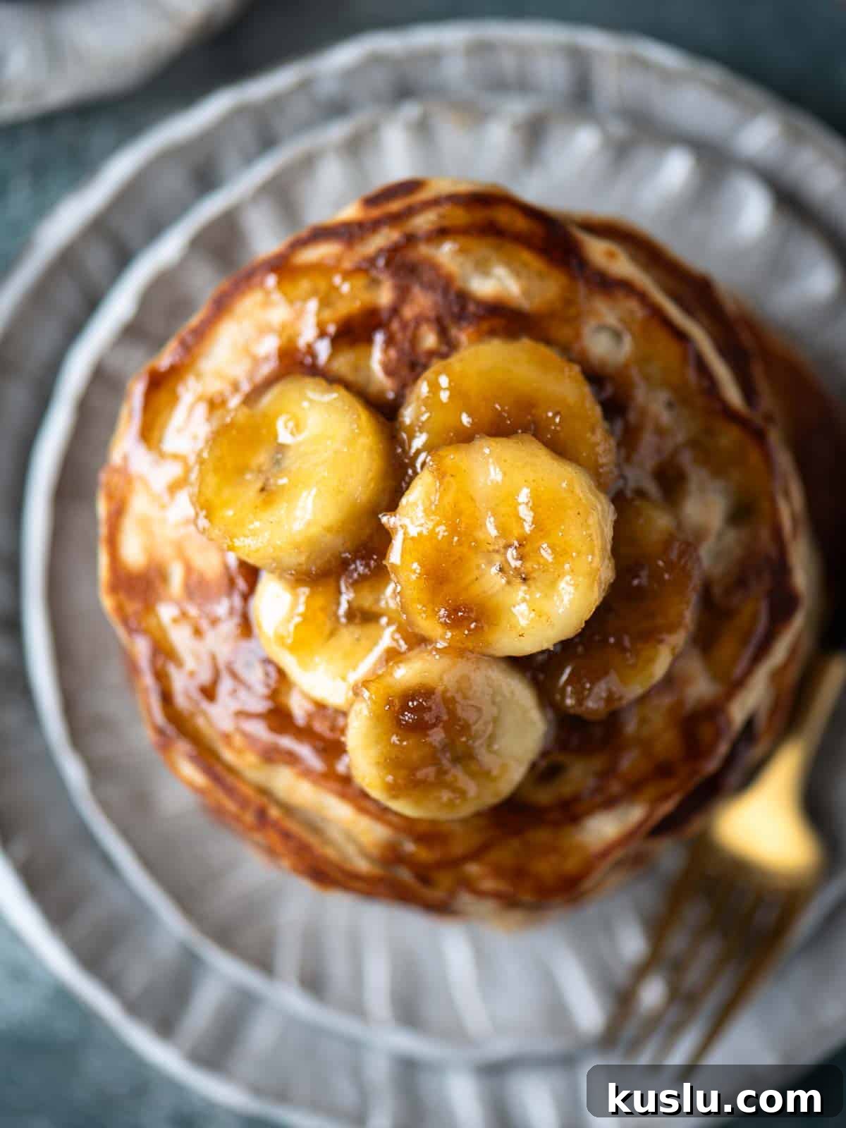 Overhead close-up of banana compote on top of a stack of pancakes.