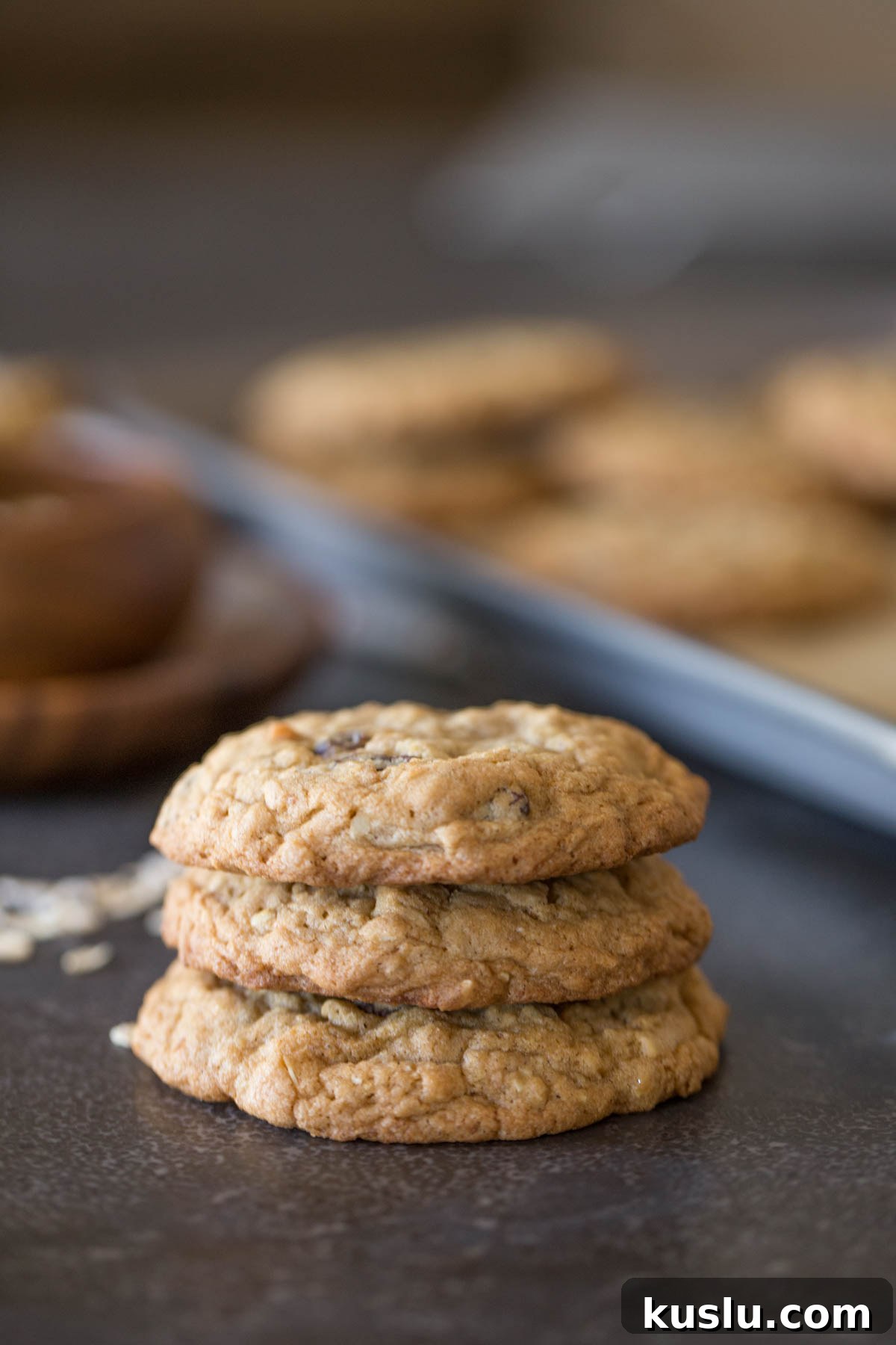 Three Bakery Style Oatmeal Raisin Cookies stacked on top of each other.  