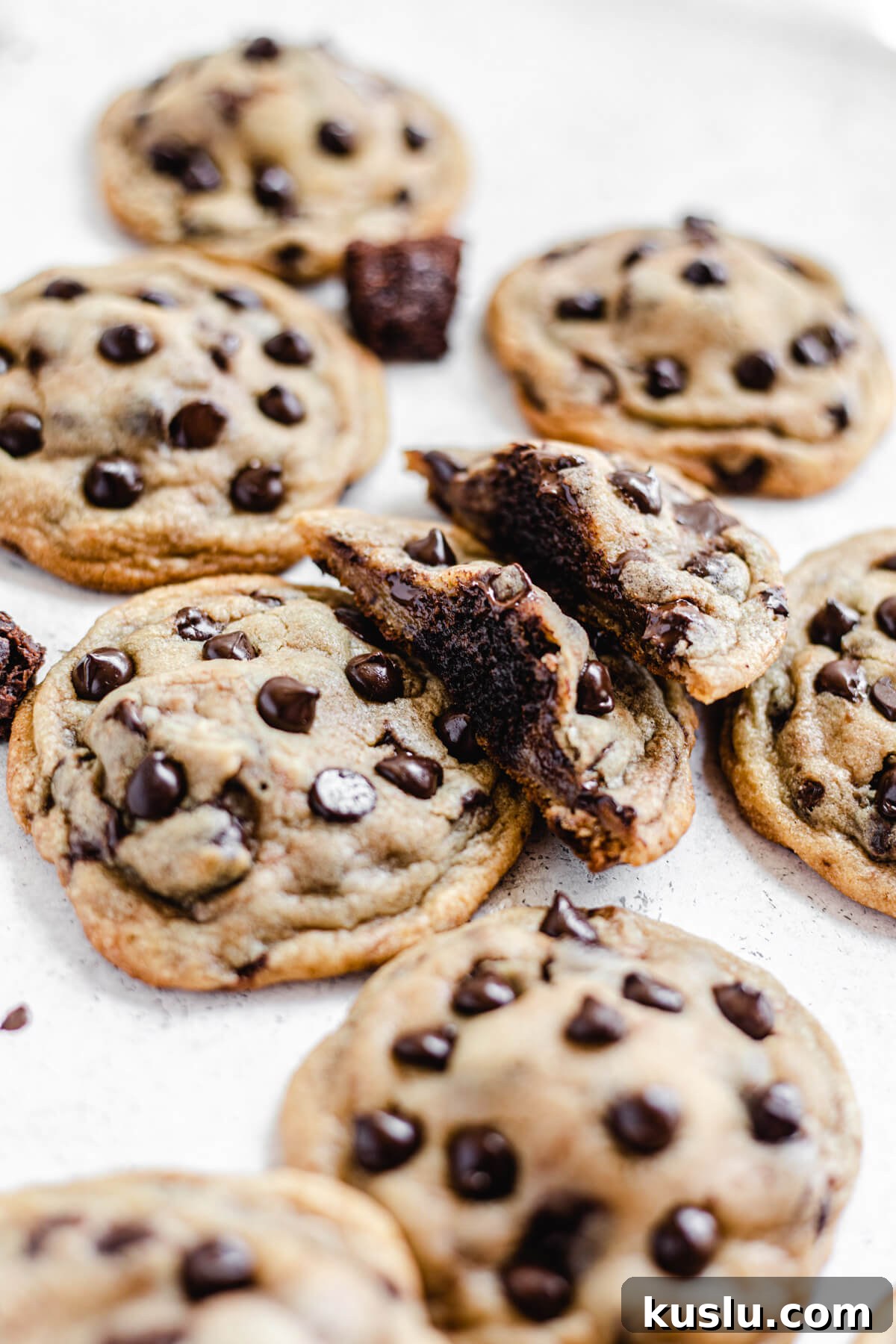 two halves of a cookie leaning on a chocolate chip cookie