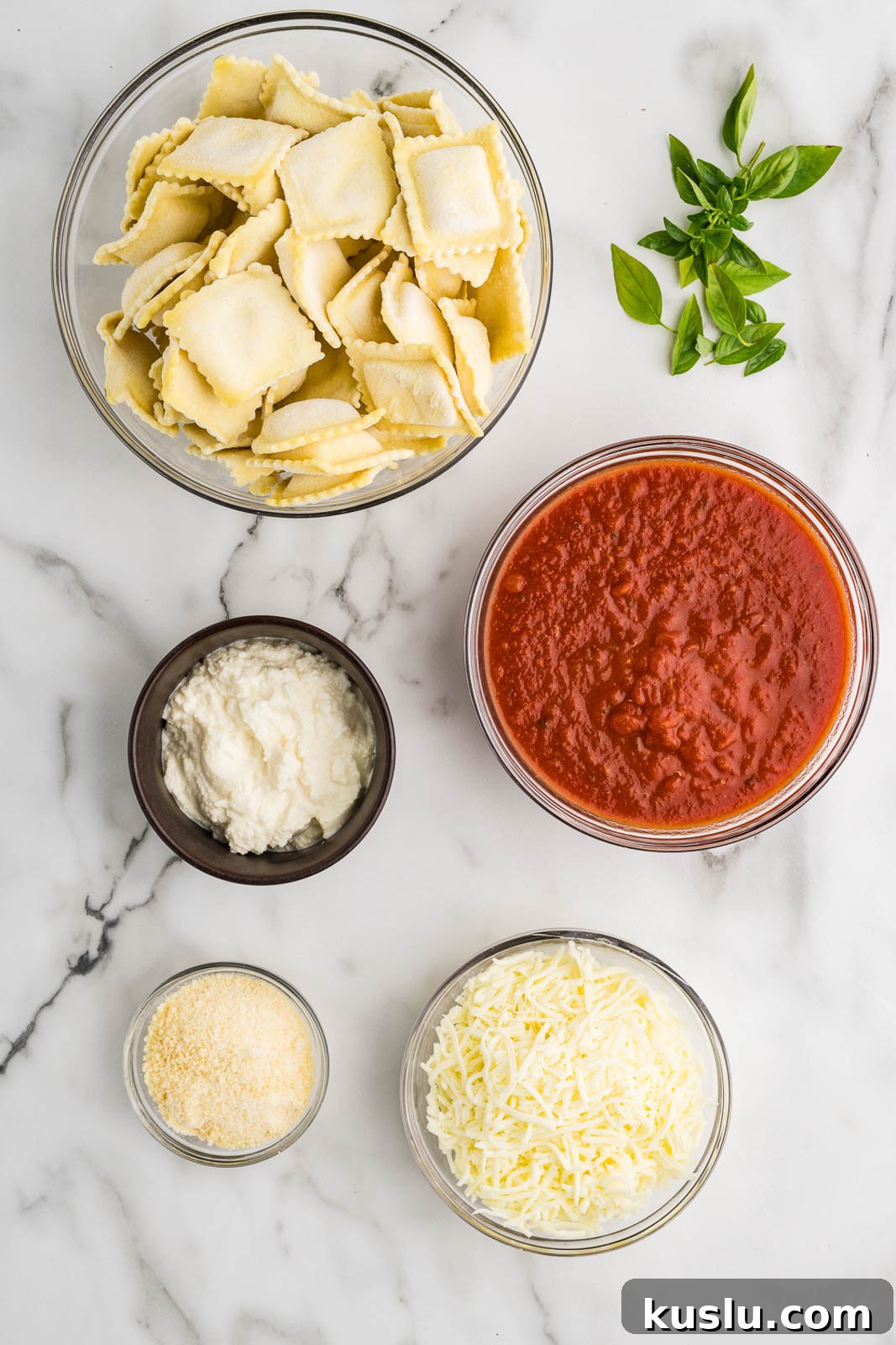 Slow Cooker Ravioli Lasagna: Comforting One-Pot Dinner 3 ravioli lasagna ingredients to include bowls of ravioli, spaghetti sauce, mozzarella cheese, Parmesan cheese, ricotta cheese and fresh basil