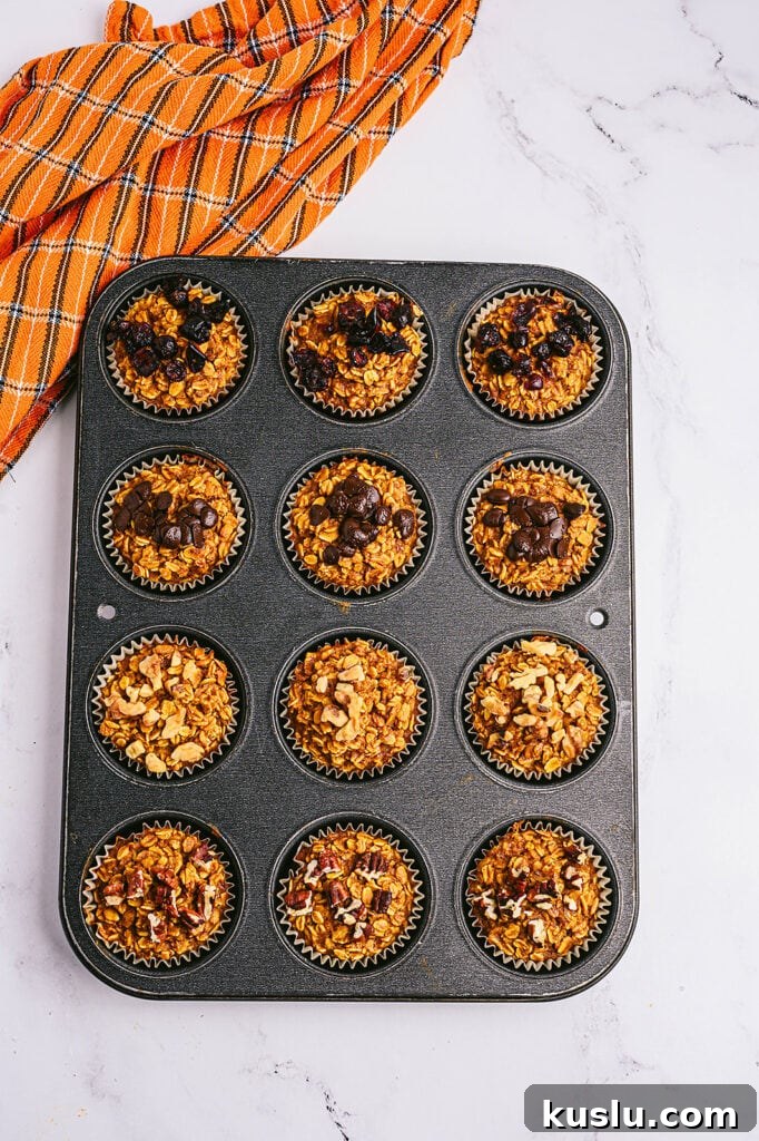 Overhead photo: pumpkin oatmeal muffins in a muffin tin, straight from the oven