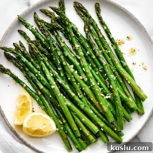 A plate of roasted asparagus with lemons.