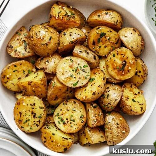 A white bowl of garlic roasted potatoes.