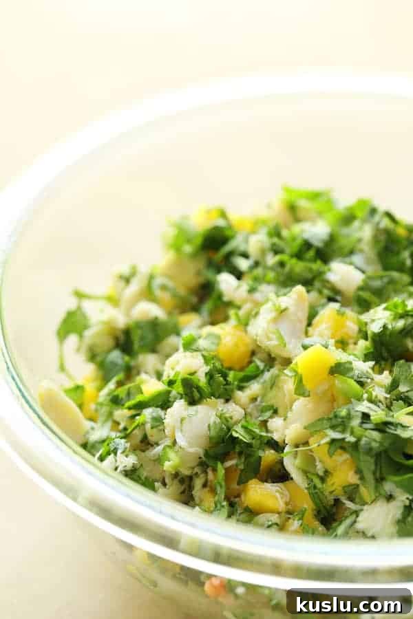 Photo of Crab Mango and Avocado Salad with Chile Lime Dressing in glass bowl.