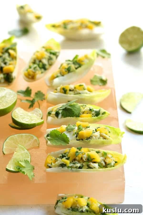 Photo of Crab Mango and Avocado Salad with Chile Lime Dressing in Endive on salt block.