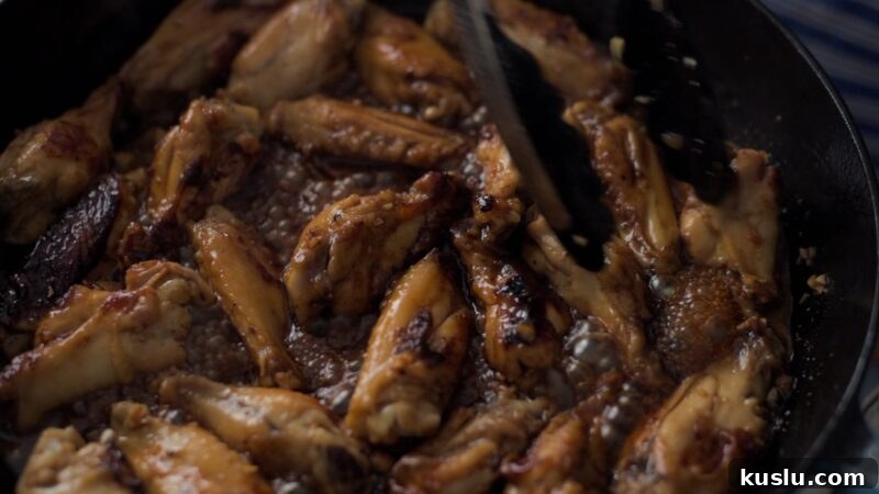 Chicken wings simmering in honey garlic sauce