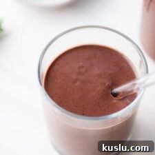 Creamy chocolate cherry smoothie in a glass with a glass straw.