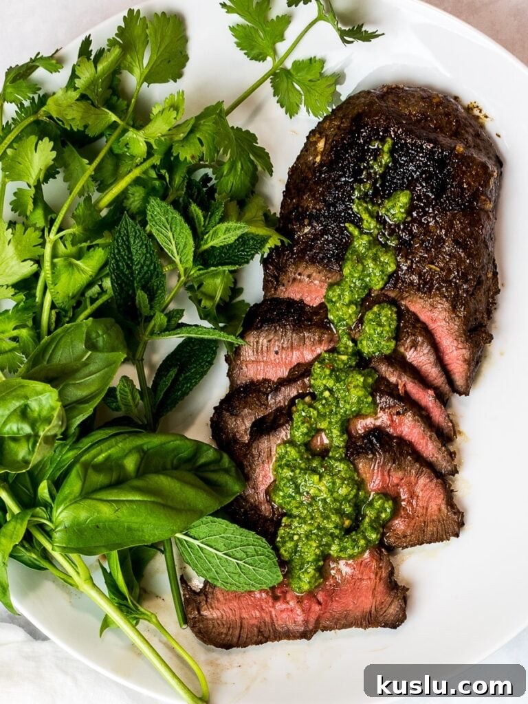 Asian marinated flank steak with herbs on a white plate