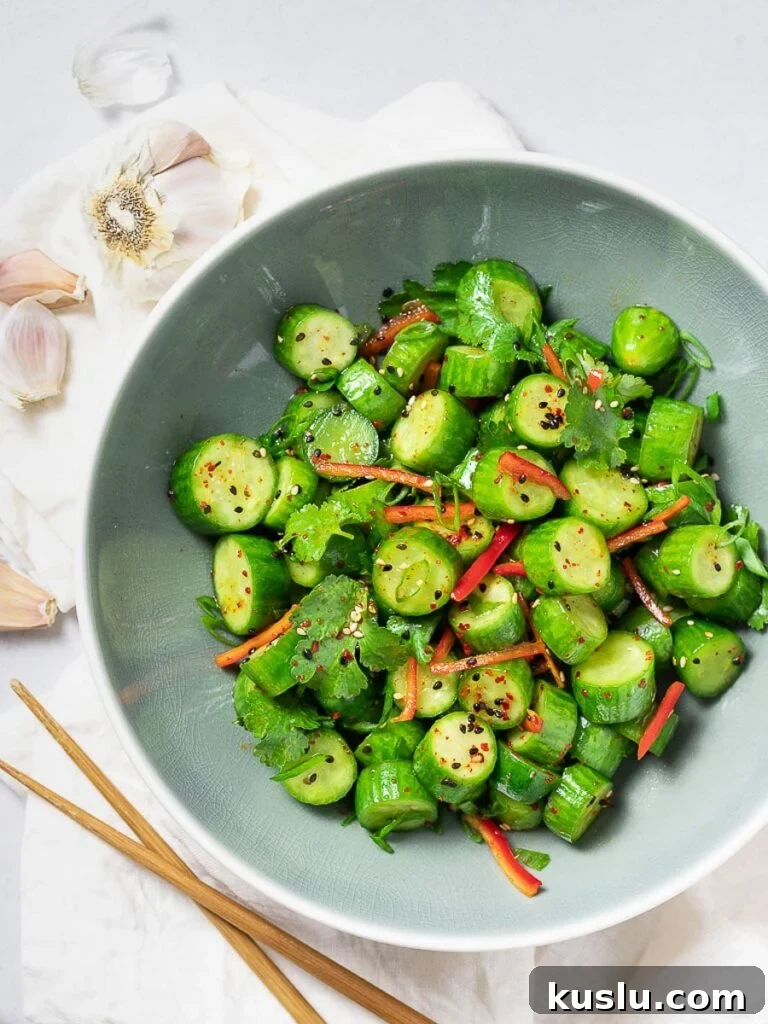 Spicy Asian cucumber salad with herbs and red pepper in a blue bowl
