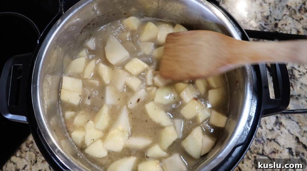 Smoothing out apples and potatoes in pot.